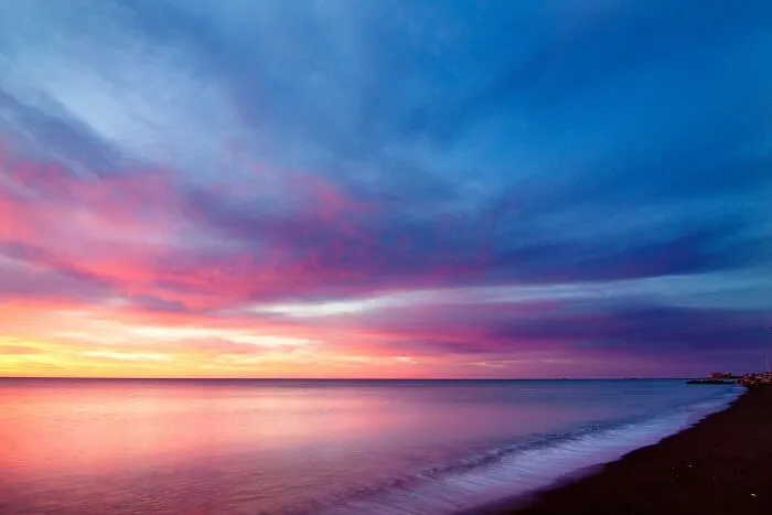 Sunset over water and seashore, highlighting colorful sky, a scene to test your wits with its serene beauty.