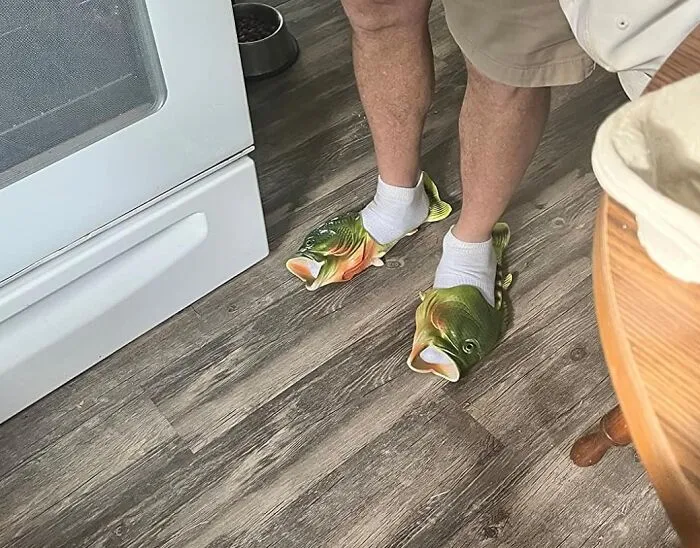 Man wearing fish-shaped slippers, adding humor to everyday life.