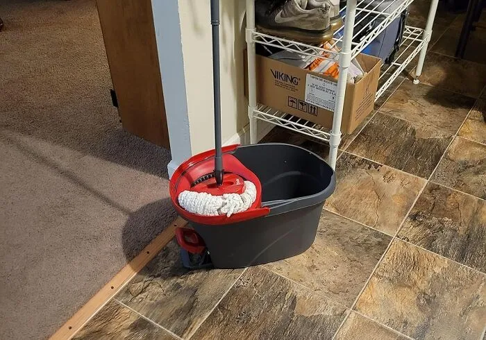 Cleaning supplies including a mop and bucket are ready for a fresh start mission in 2025.