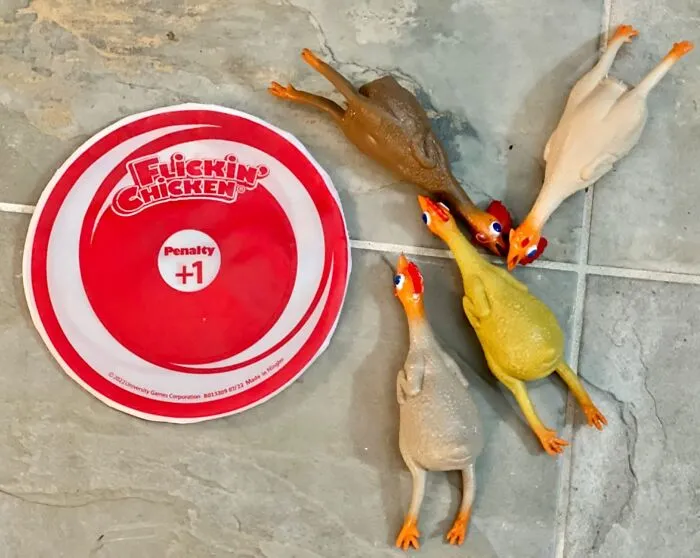 Funny products: rubber chickens next to a Flickin' Chicken target on a tiled floor.