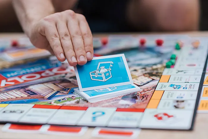 Person Picking a Monopoly Card