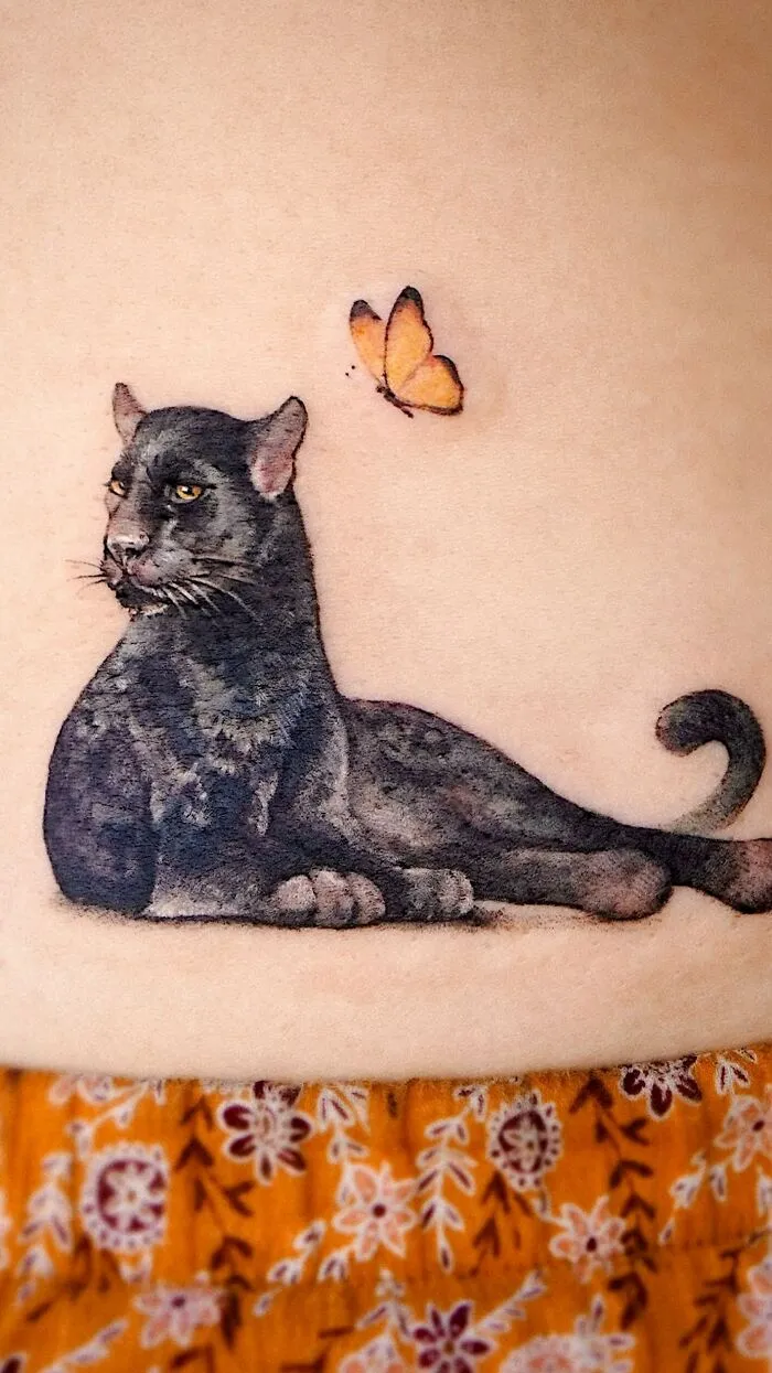 Tattoo of a panther with a butterfly, showcasing elements of nature and animals by a Korean ink artist.
