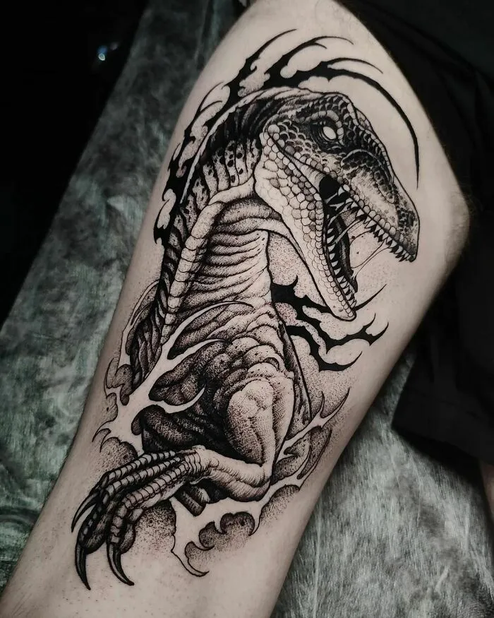 Detailed dinosaur tattoo on a leg, showcasing excellent artistic execution and design.