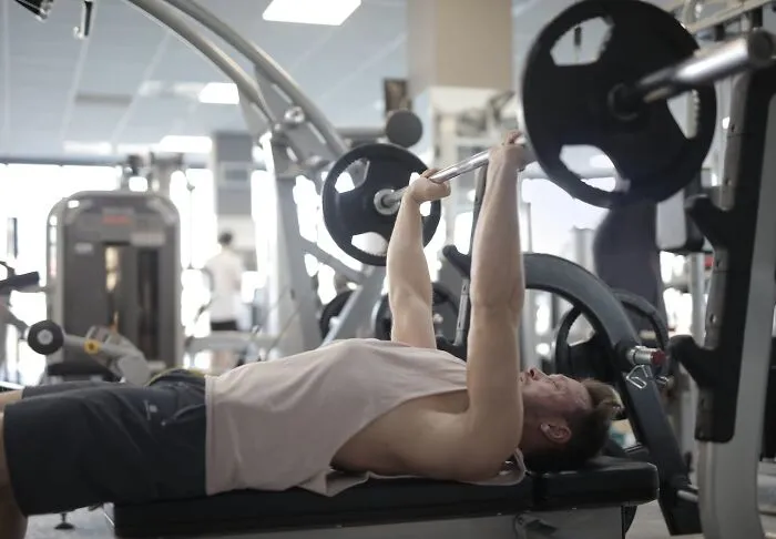 A man doing a bench press at the gym, an image unrelated to horrible resumes.