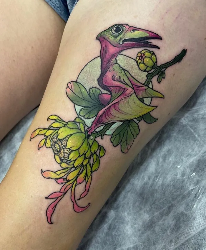 Colorful dinosaur tattoo with floral elements perfectly executed on skin.