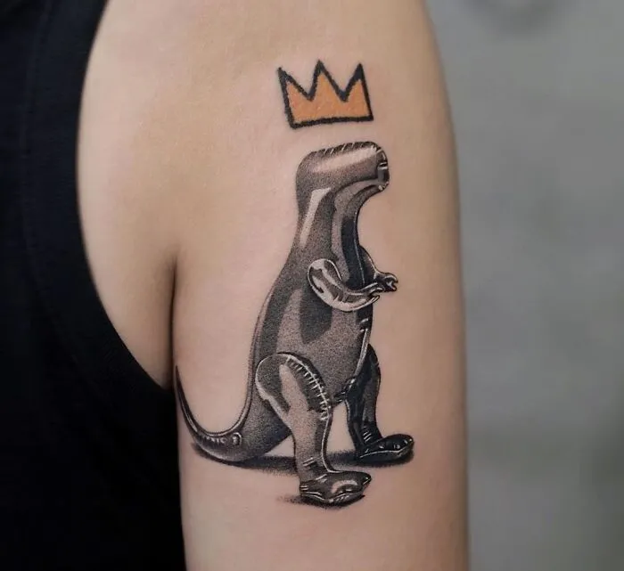 Cool dinosaur tattoo on arm with crown design above.