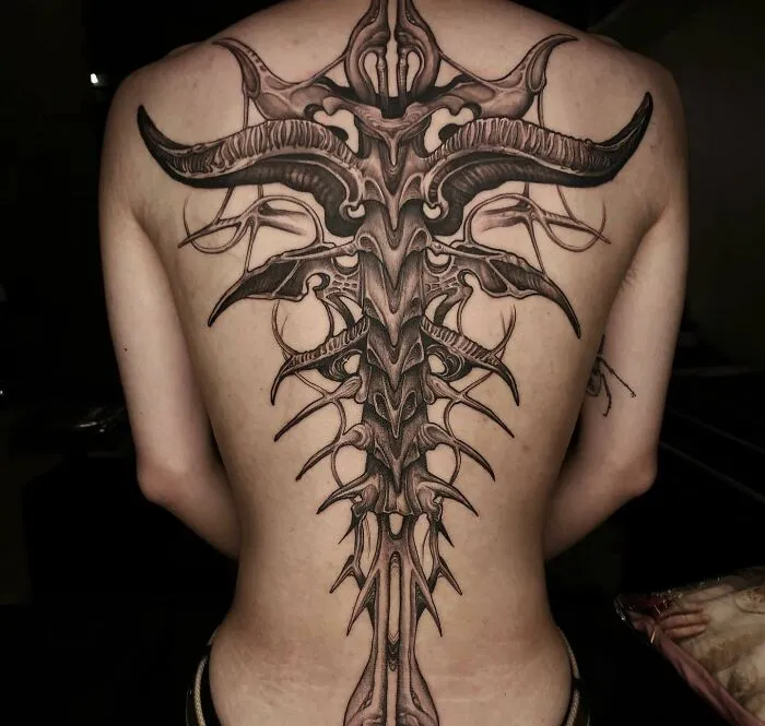 Intricate spine tattoo design covering entire back, showcasing detailed artistry.
