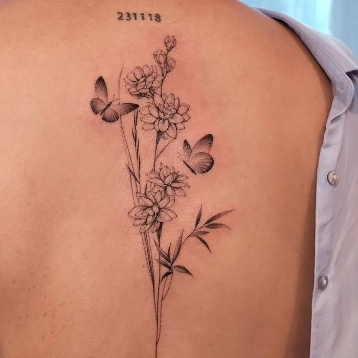 Floral spine tattoo with butterflies on back, showcasing intricate beauty and elegance.