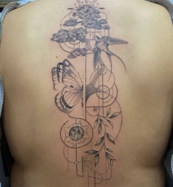 Beautiful spine tattoo featuring a hummingbird, butterfly, geometric shapes, and leaves.