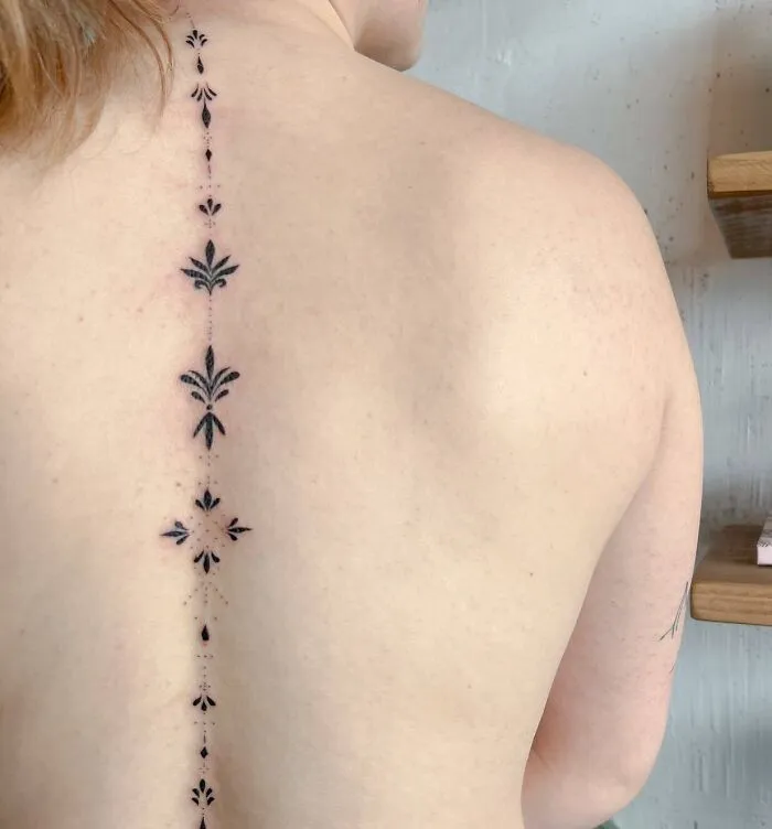 Elegant floral spine tattoo along the back, showcasing intricate design and symmetry.