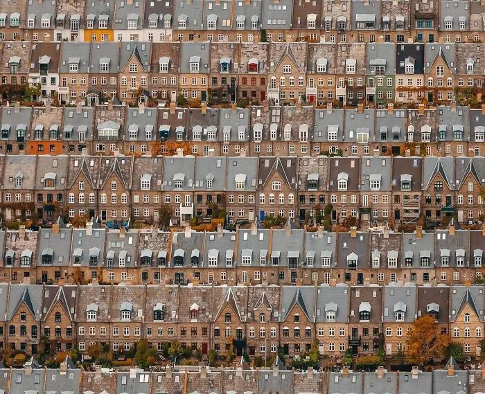 Aerial view of symmetrical row houses with varied roof designs, showcasing enjoyable architectural design patterns.