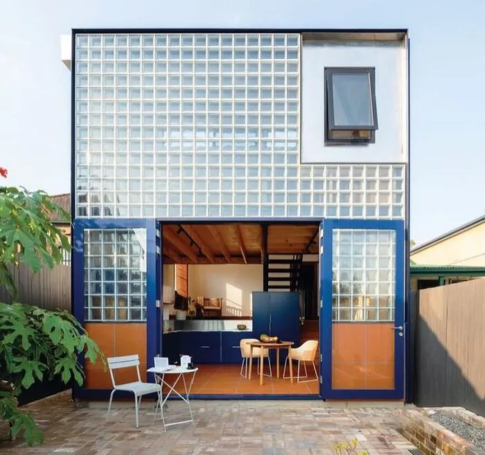 Modern architectural design with glass bricks and blue accents on a two-story house facade.