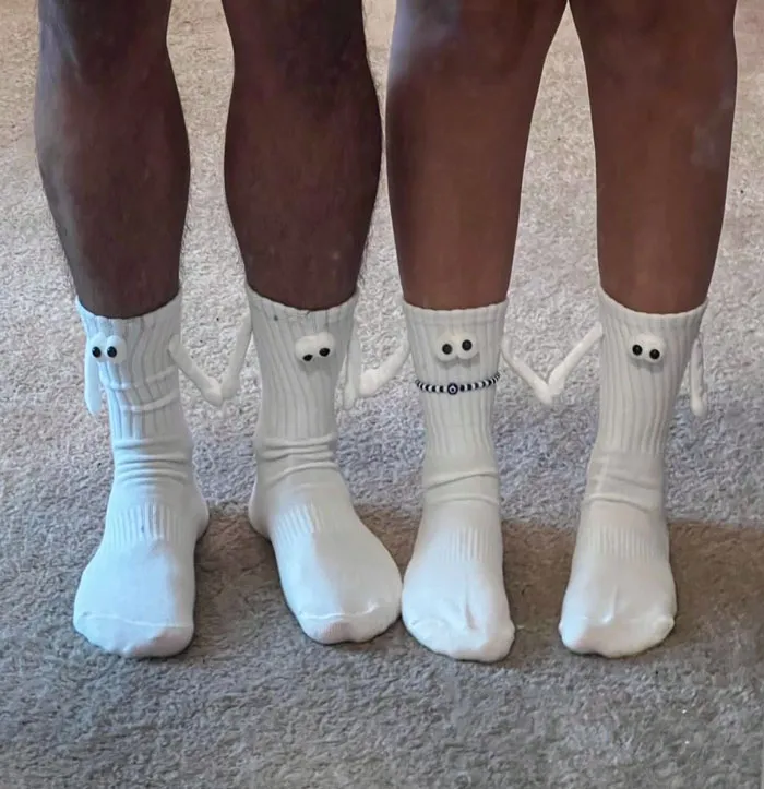 Two pairs of legs wearing cute, novelty socks with googly eyes, perfect affordable Valentine's Day gift idea.