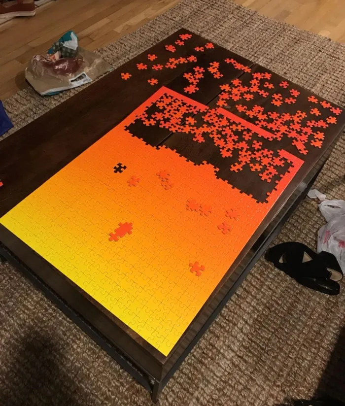 Valentine's Day gift idea: vibrant orange and yellow puzzle partially completed on a wooden table.