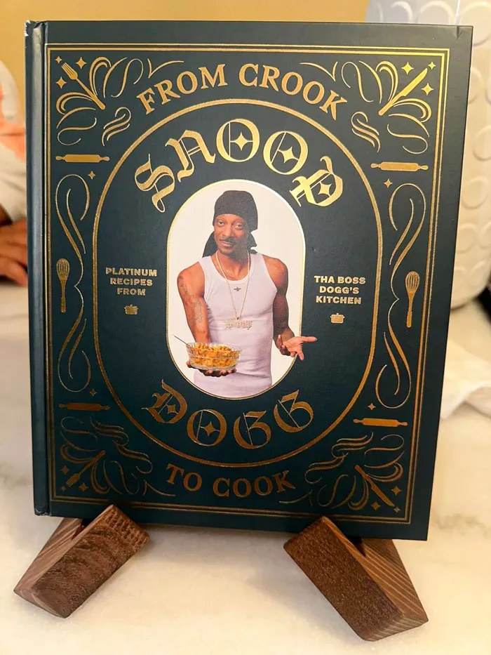 Cookbook titled "From Crook to Cook" on a wooden stand; a budget-friendly Valentine's Day gift idea.