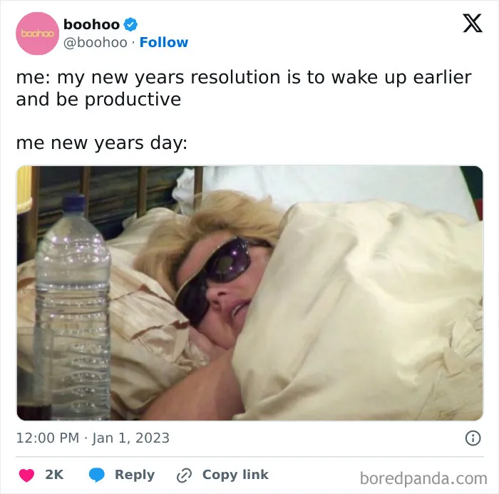 Person wearing sunglasses lying in bed wrapped in blankets, humorously illustrating new year's resolutions on New Year's Day.