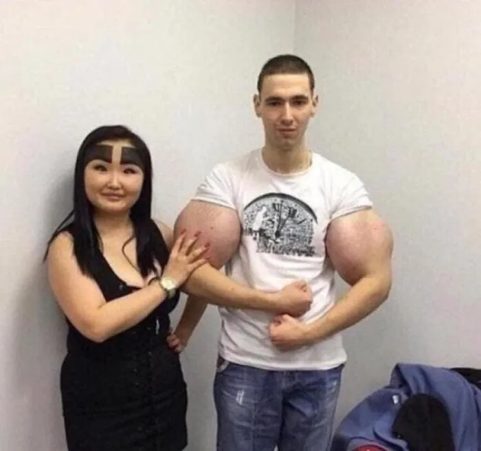 Two people posing, with one showing extremely large arm muscles, exemplifying cursed pics.