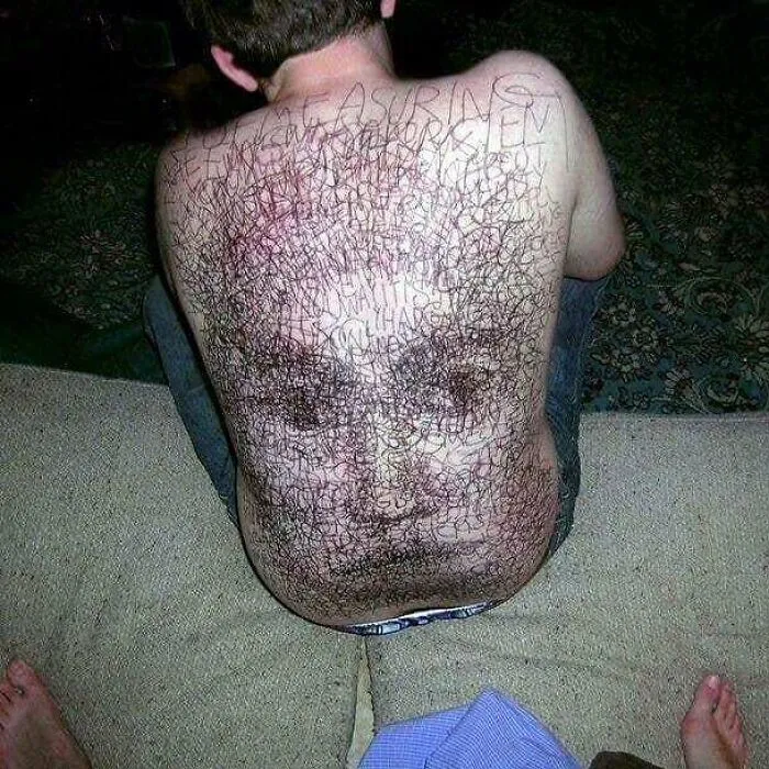 A person's back with a face drawn on it, creating a cursed and bizarre appearance.