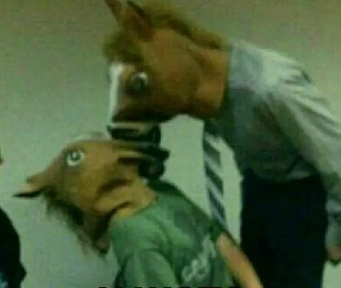 Two people wearing horse masks, leaning towards each other in a humorous, cursed image.
