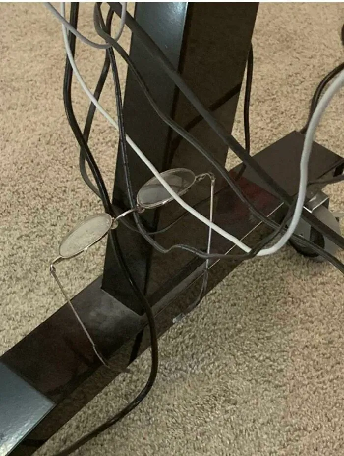 Tras varios días sin encontrar mis gafas, ir a examinarme los ojos de nuevo y encargar gafas nuevas... las encontré enredadas en los cables bajo la mesa