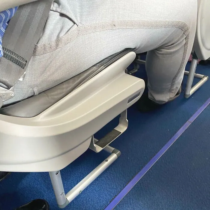 Asiento de avión con un peldaño para que los bajitos lleguen mejor al portaequipajes superior