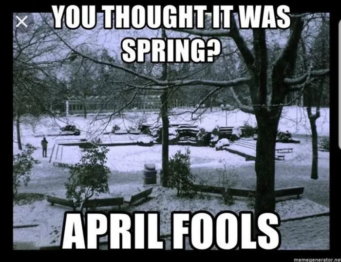 Snow-covered park with trees and benches, text reads "You thought it was spring? April Fools"—funny spring meme.
