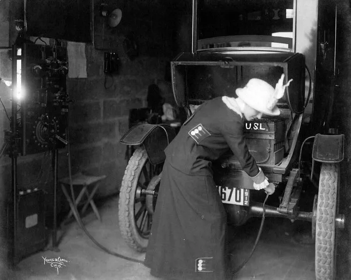 Mujer enchufando su coche eléctrico en 1912