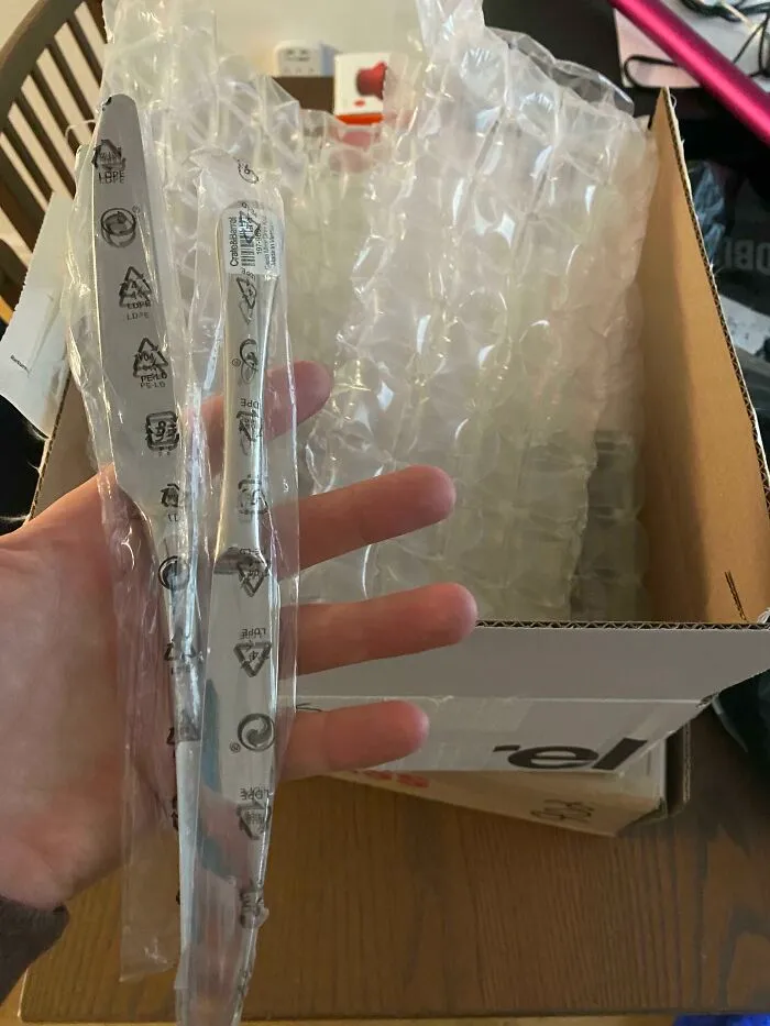 Excessive product packaging with bubble wrap for small item in a box, highlighting wasteful packaging practices.