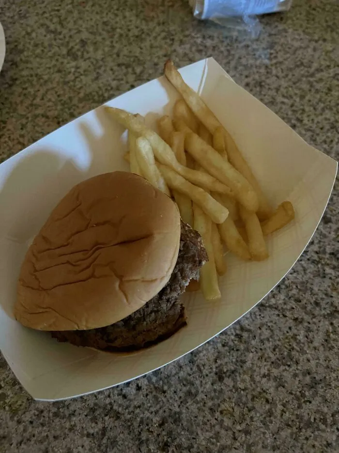 Simple burger and fries in a paper tray on a kitchen counter, showing a classic dad meal moment.