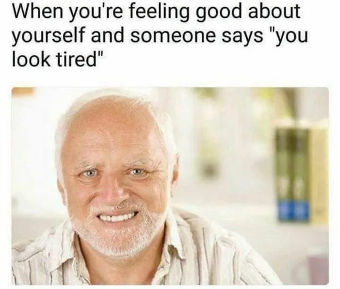 Man smiling awkwardly in relatable meme about introverts feeling good then being told they look tired.