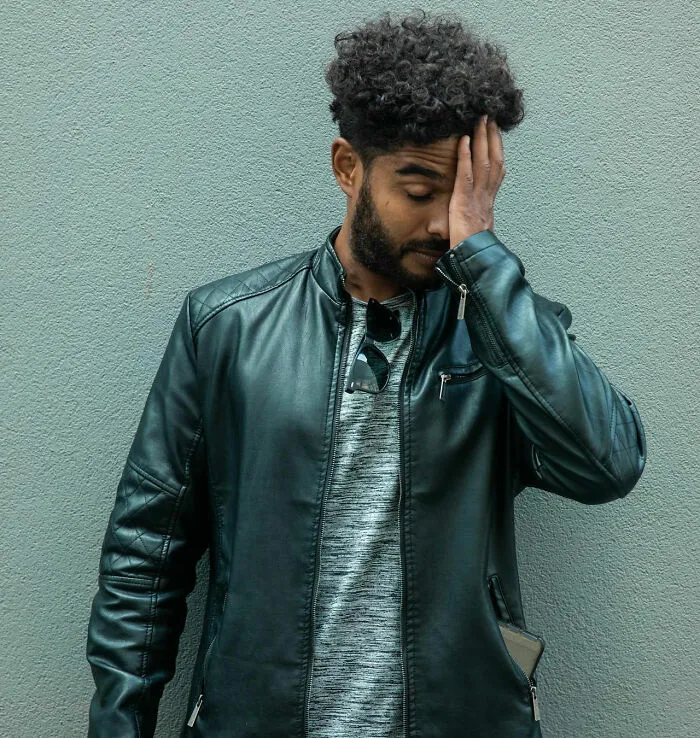 Man in a leather jacket looking frustrated, capturing the idea of unfortunate names given to babies.