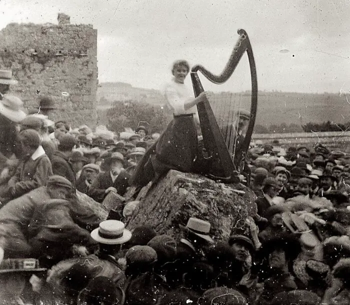 Una mujer tocando el arpa ante una gran multitud, Roca de Cashel, Irlanda, 1910 aprox