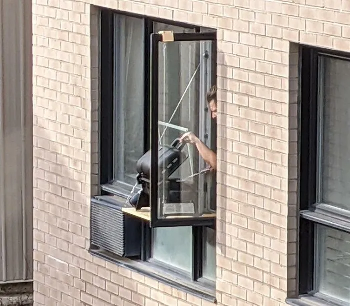 El vecino haciendo una barbacoa en la ventana del salón