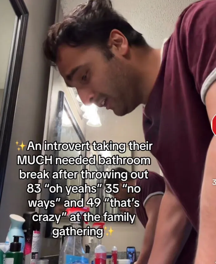Man takes a bathroom break during a family gathering, with humorous text about introverts.