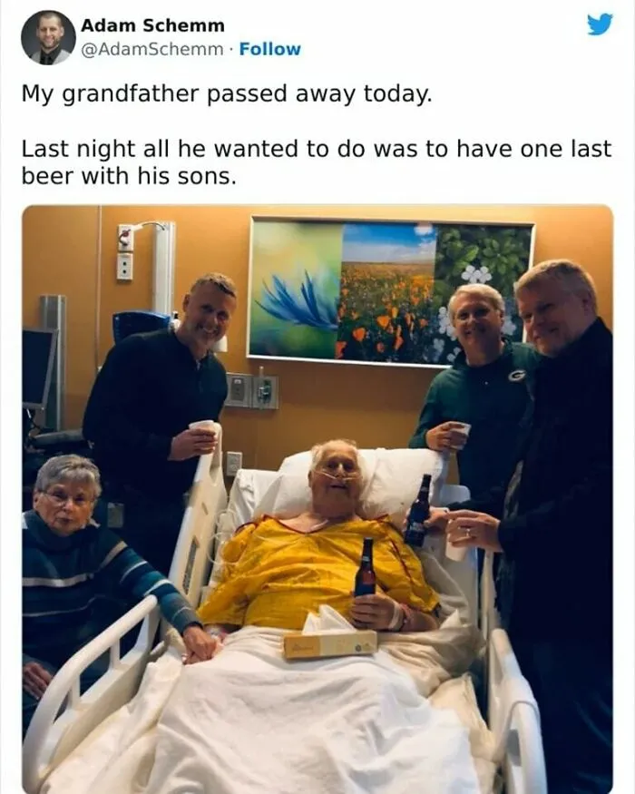 Family sharing a wholesome moment around a hospital bed, each holding a drink and smiling together.
