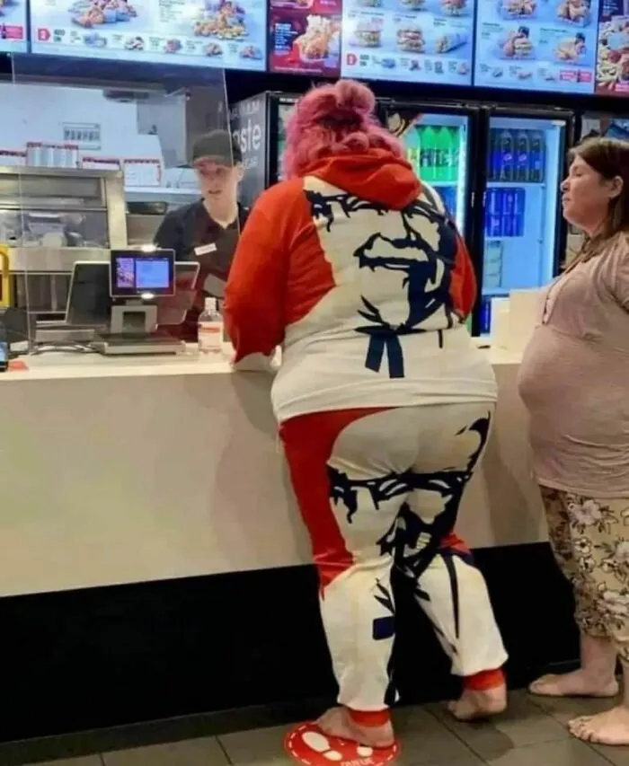 Person in fast-food restaurant wearing a Colonel Sanders tracksuit, illustrating humans of capitalism pictures.