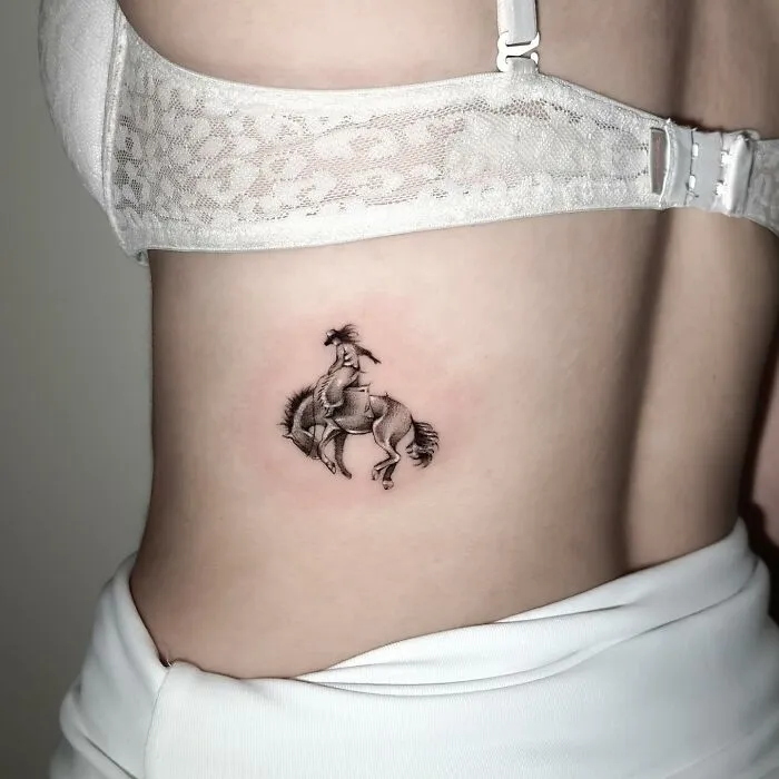 Single needle tattoo of a horse on a person's side, displaying detailed shading and design.