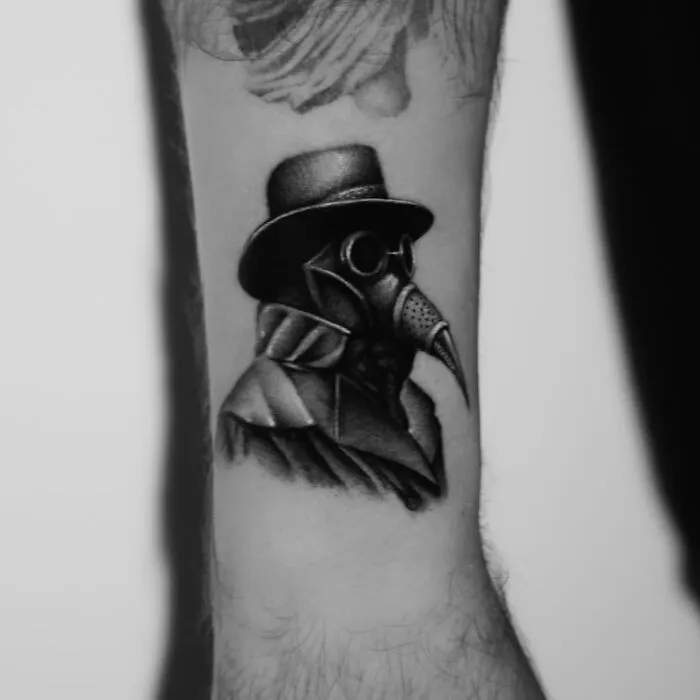 Single needle tattoo depicting a detailed plague doctor design on an arm.