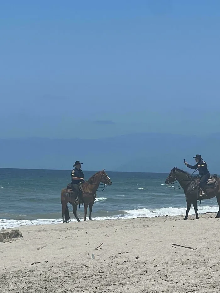 La policía montada haciéndose fotos en la playa