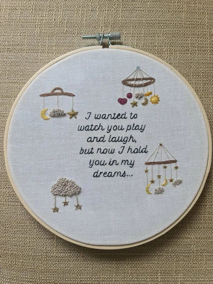 Creative embroidery piece featuring hanging stars and a heartfelt message in a hoop.