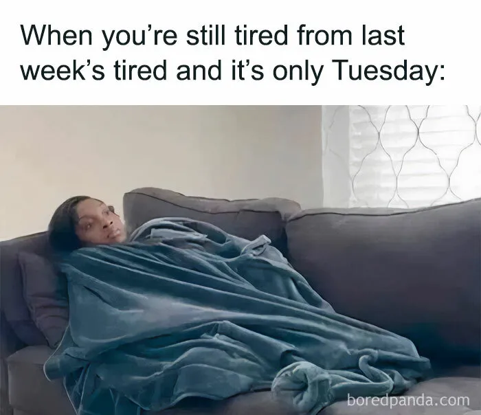 Person wrapped in a blanket on a couch, looking tired with a caption about feeling exhausted on Tuesday.