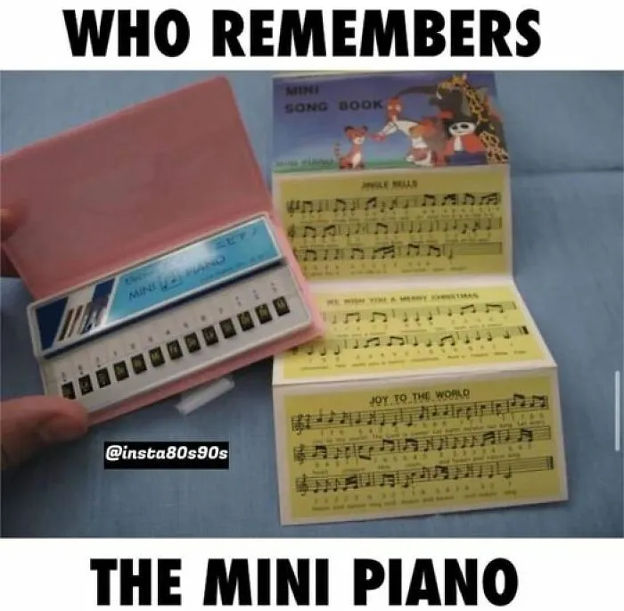 '90s mini piano toy with open songbook, featuring nostalgic music sheets and keys in a pink case.