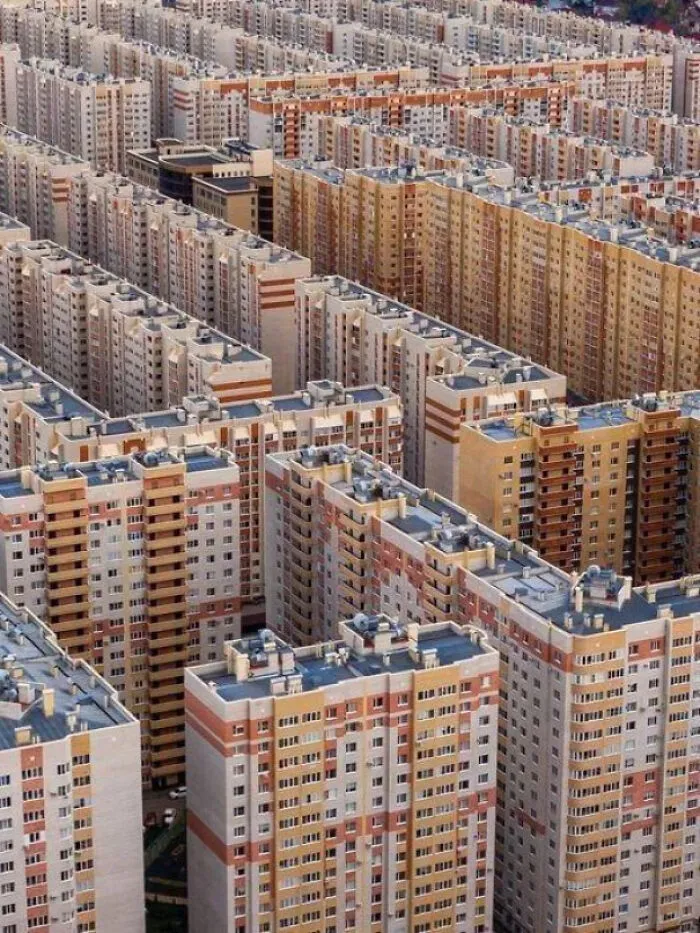 A vast cluster of tall apartment buildings creating a dense, overwhelming scene causing megalophobia fear.