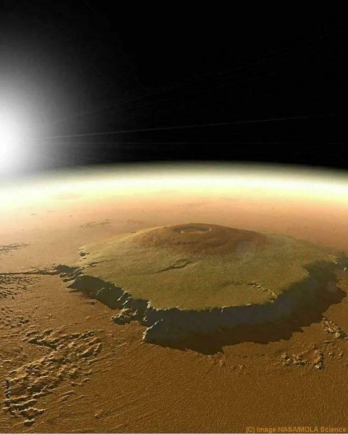 Large massive mountain on a barren planet surface with sun shining in the distance, evoking megalophobia feelings.