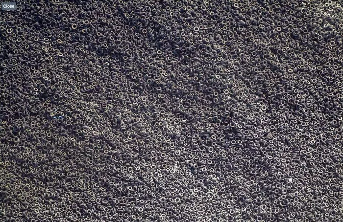 Aerial view of an enormous mountain of discarded tires creating a sprawling, chaotic scene for megalophobia.