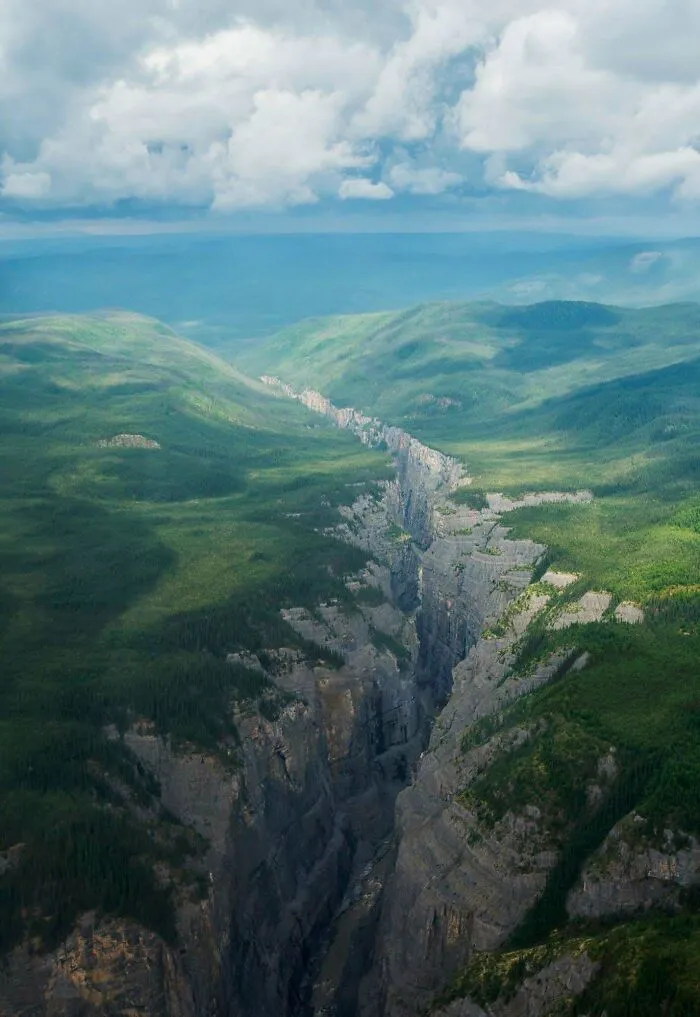 Gran fisura profunda entre montañas verdes que muestra por qué las cosas extremadamente grandes pueden ser aterradoras.