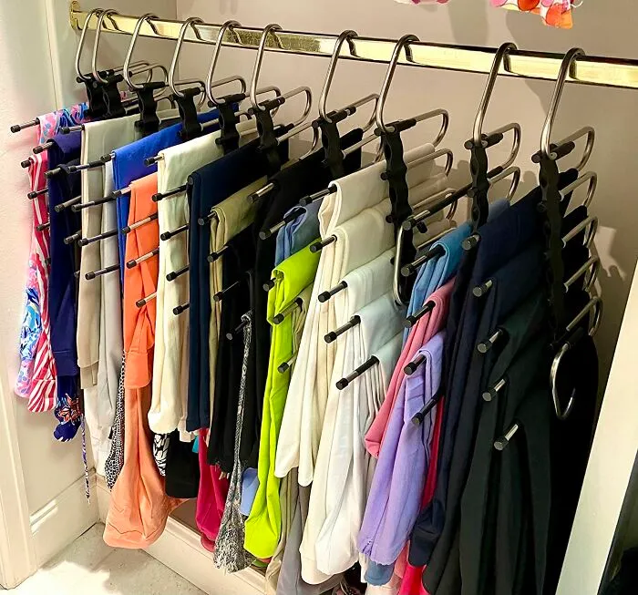 Maximize your closet space and say goodbye to cramped quarters! Instead of wasting valuable vertical space, try incorporating space-saving multi-item <a style="display:inline;" href="https://www.amazon.com/Magic-Pants-Hangers-Space-Saving/dp/B091KFT7WN?crid=3MVQ9RBWJKUSB&dib=eyJ2IjoiMSJ9.xBW-Pk6xzQJdJujaQVGc3L5SQhCX2bmbE8vnaoIWi0vZiOYY8IioEoLIaldNVYBrKTb_5wV2s7riqTOXz49FOxPv0jM8ascULg8OV9U7gXnzzhV5ya3YH13RYtz9TSXCqhK7qQLEhyn7O-x7YJ9KsR5F7xCg6o0BuSOLknpsQMyLLc65e2oOiTJdyQveG6czDzWrNBY7o_mu6yFrMgVSybppeMTpTbNB53MurGw8mc5c2rfNVbSR081PPuliIx7cD7sedu27578C-uyRpRh0-9CBlgpLO805We_RtegqBPc.LViWnZfEAkOaDckBZQbmLh1eeHVOCGkSLag-rxp1WJ0&dib_tag=se&keywords=multi+item+clothes+hangers&qid=1723180791&sprefix=multi+ite%2Caps%2C333&sr=8-1-spons&sp_csd=d2lkZ2V0TmFtZT1zcF9hdGY&psc=1&linkCode=ll1&tag=bpcamel-20&linkId=f2d6fb0d23d082db566182c2b7d6061c&language=en_US&ref_=as_li_ss_tl " target="_blank"><span style="font: inherit; color: #d74b1f;">pants hangers</span>. These clever hangers allow you to hang multiple pairs of trousers or blouses in a cascading fashion, instantly multiplying your hanging capacity.