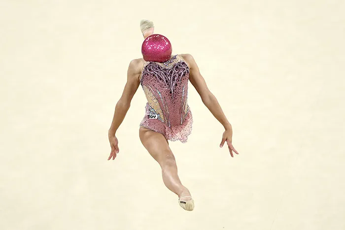 Italy’s Sofia Raffaeli Holds A Ball In Her Neck As Her Body Reaches A Level Of Mid-Air Tension So That Her Head Seems All But Replaced By The Object