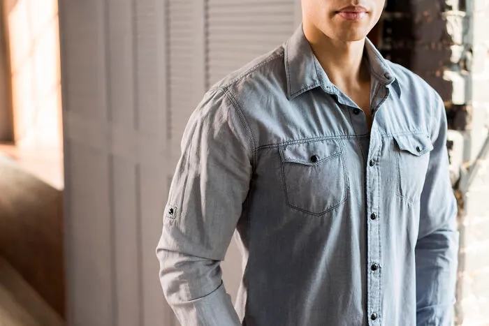 Young man wearing a casual denim shirt standing indoors, representing things people started appreciating after they got older.