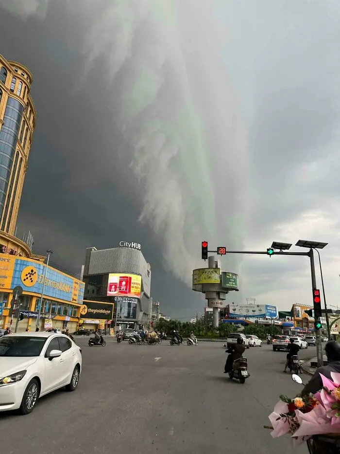 Nubes extremadamente grandes y oscuras sobre una ciudad con tráfico, mostrando por qué las cosas grandes pueden ser aterradoras.